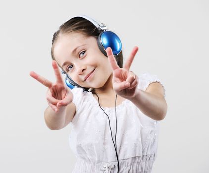 Beautiful girl shows a symbol of a victory.
