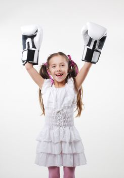 Smiling little girl wearing boxing gloves