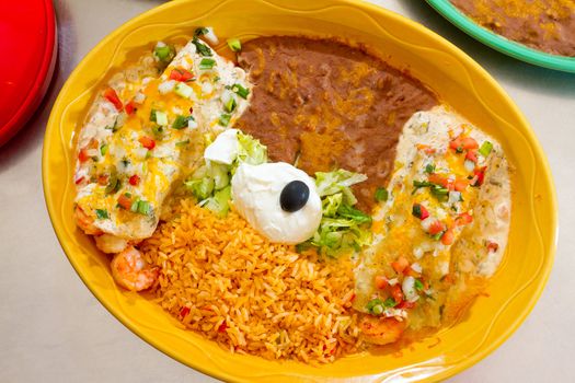 Enchiladas and rice and beans at a Mexican restaurant serving authentic cuisine.