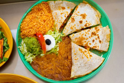 An authentic quesadilla at Mexican restaurant with rice and beans.