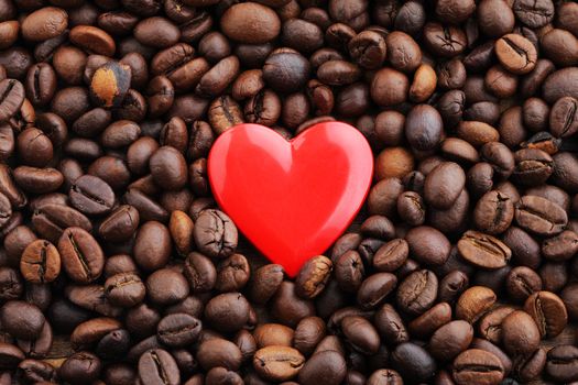 Textures of roasted coffee beans with red heart for background