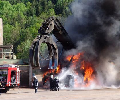 Firefighter putting out the Fire of a big Machine