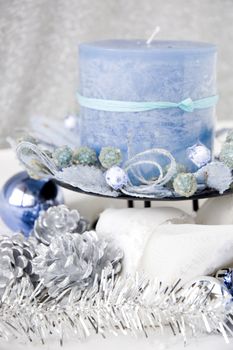 close up blue candle decorated with christmas ornaments