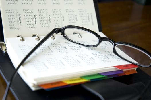 eyeglasses put on calendar page of personal organizer