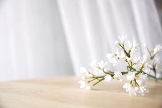 white artificial flowers put on table window side 
