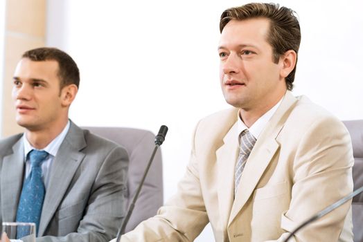 two businessmen sitting in a chair at the table, talk at the conference