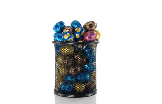 metal container filled with easter eggs in red blue yellow and brown