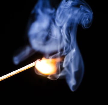 Match ignition with smoke over black background