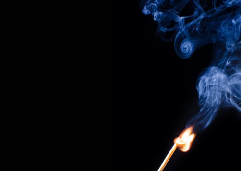 Match ignition with smoke over black background