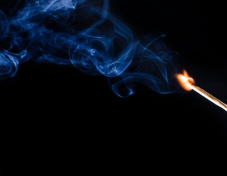 Match ignition with smoke over black background