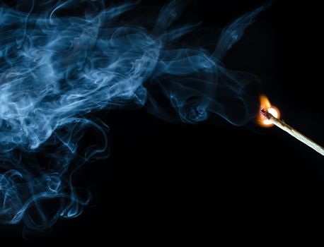 Match ignition with smoke over black background