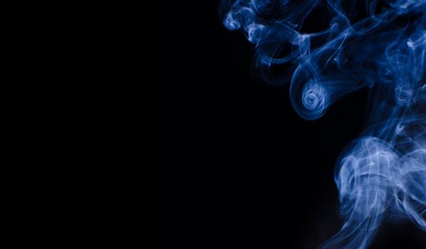 Blue smoke curls over black background