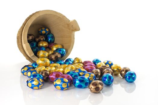 wooden bucket with easter eggs in red blue yellow and pink