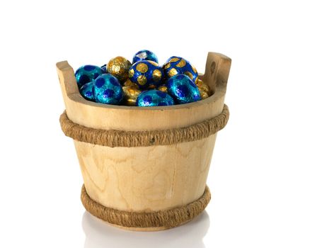 wooden bucket with easter eggs isolated on white