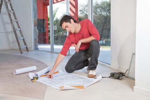 Young architect analyzing blueprint with concentration