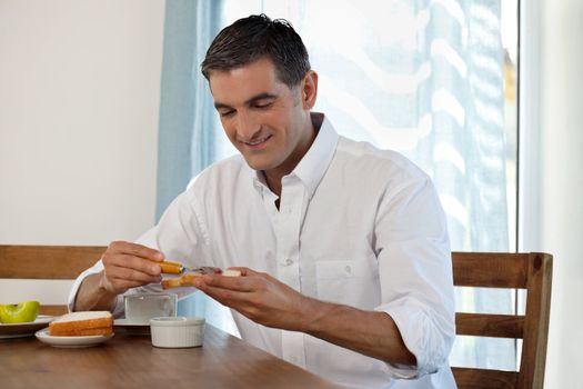 Middle aged man having breakfast at home