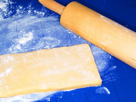 Dough on blue silicon mat, with wooden pin