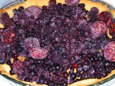 Round pie with frozen assorted dark berries
