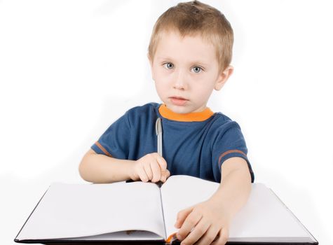 Boy with the pen writes in a notebook