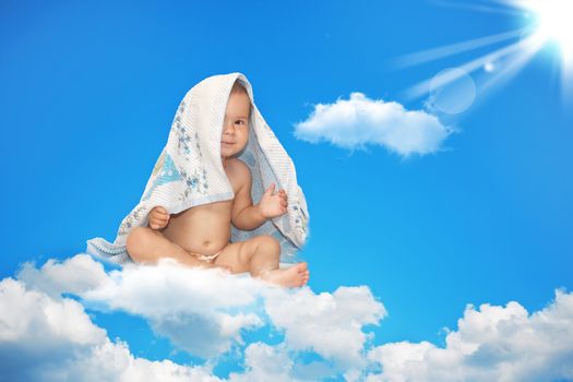 The small child sits on a white cloud in the sky