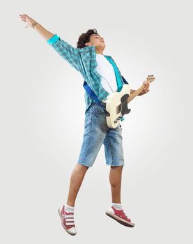 young man playing on electro guitar and jumping