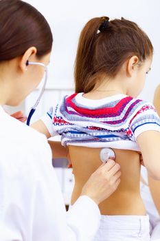 Little girl and young doctor in hospital having examination