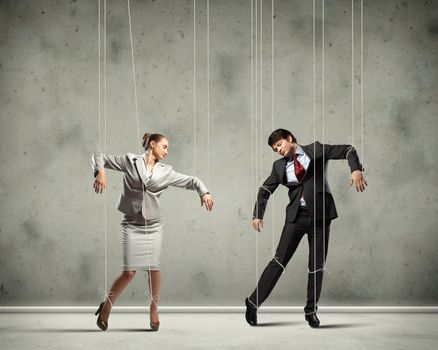 Image of businesspeople hanging on strings like marionettes. Conceptual photography