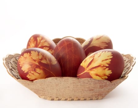 Easter eggs in a decorative basket on a light background