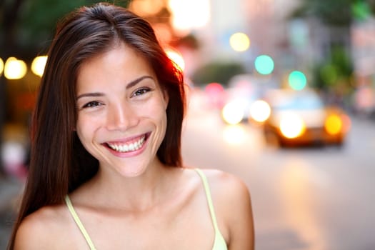 Asian woman portrait in New York City. Beautiful young mixed race Asian Chinese / Caucasian woman in her twenties smiling happy looking at camera.