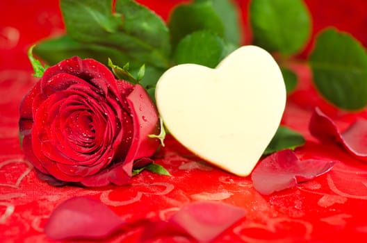 Valentine's image of a white shaped chocolate heart with a rose with copyspace.