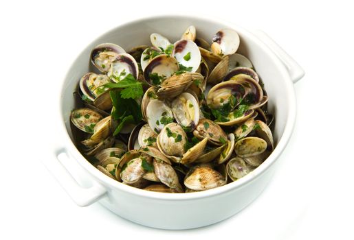 white bowl of clams soup with parsley on white background