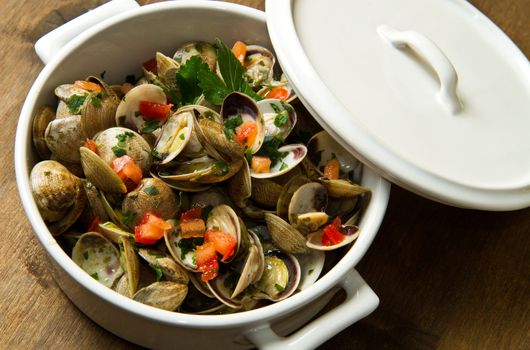 a delicious clams soup with tomatoes on white bowl