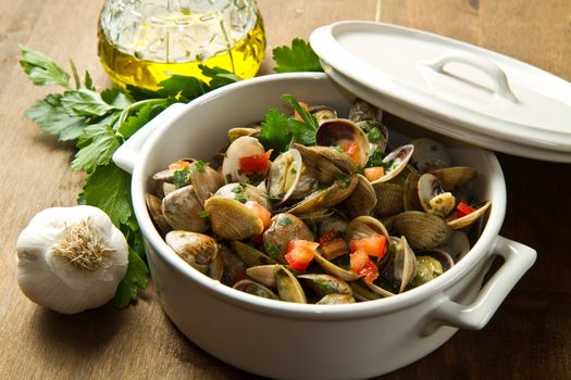 bowl with delicoius clams soup on wooden table