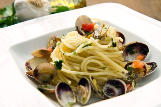 dish of spaghetti with clams on wooden table