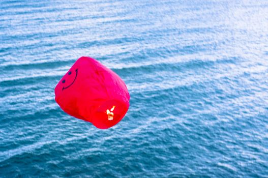 An image of red hot air balloon over the sea