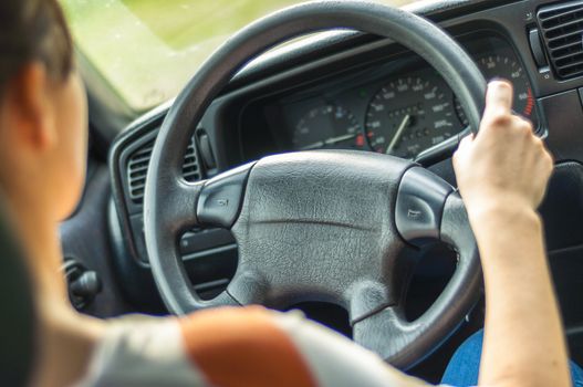 Hands of a female driver on steering wheel
