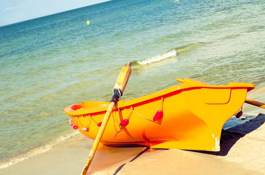An image of orange rescue boat on the beach of baltic sea