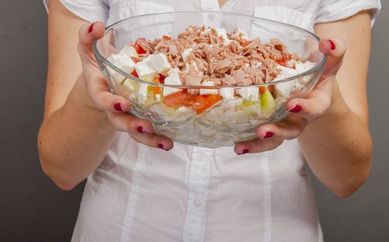 An image of girl holding tuna salad in salad bowl
