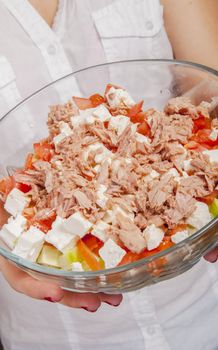 An image of girl holding tuna salad in salad bowl