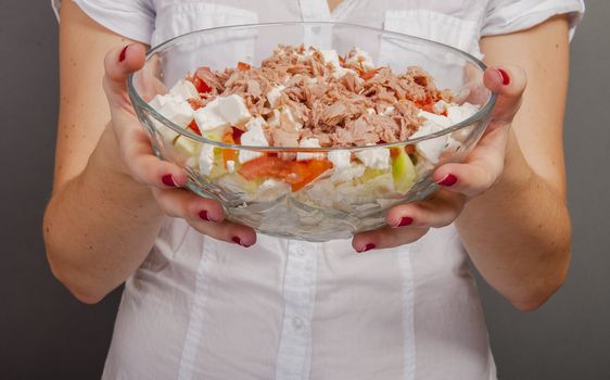 An image of girl holding tuna salad in salad bowl