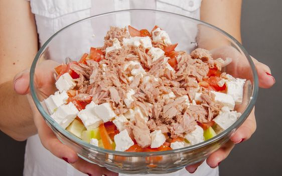 An image of girl holding tuna salad in salad bowl
