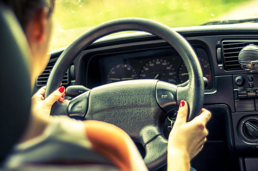 Hands of a female driver on steering wheel
