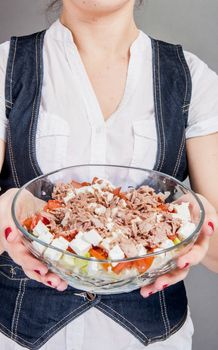An image of girl holding tuna salad in salad bowl