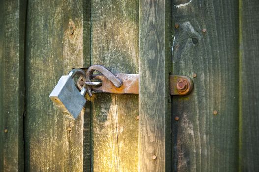 An image of closed old wooden door with padlock
