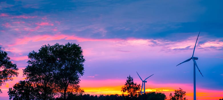 An image of windturbine against amazing sunset