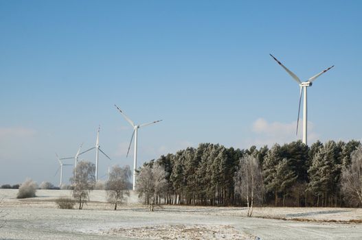 An image of winter scenery with windturbines in the background 