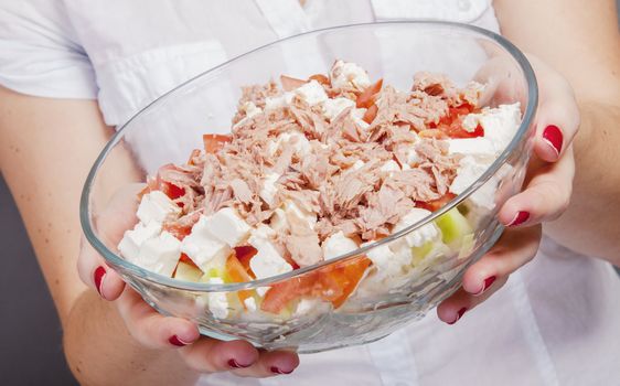 An image of girl holding tuna salad in salad bowl