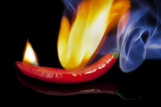 An image of red hot chilli pepper with flame