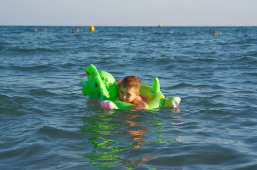 Little boy in the waves on the sea beach