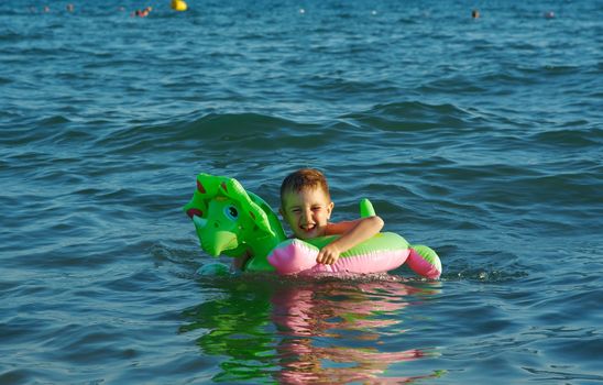 Little boy in the waves on the sea beach